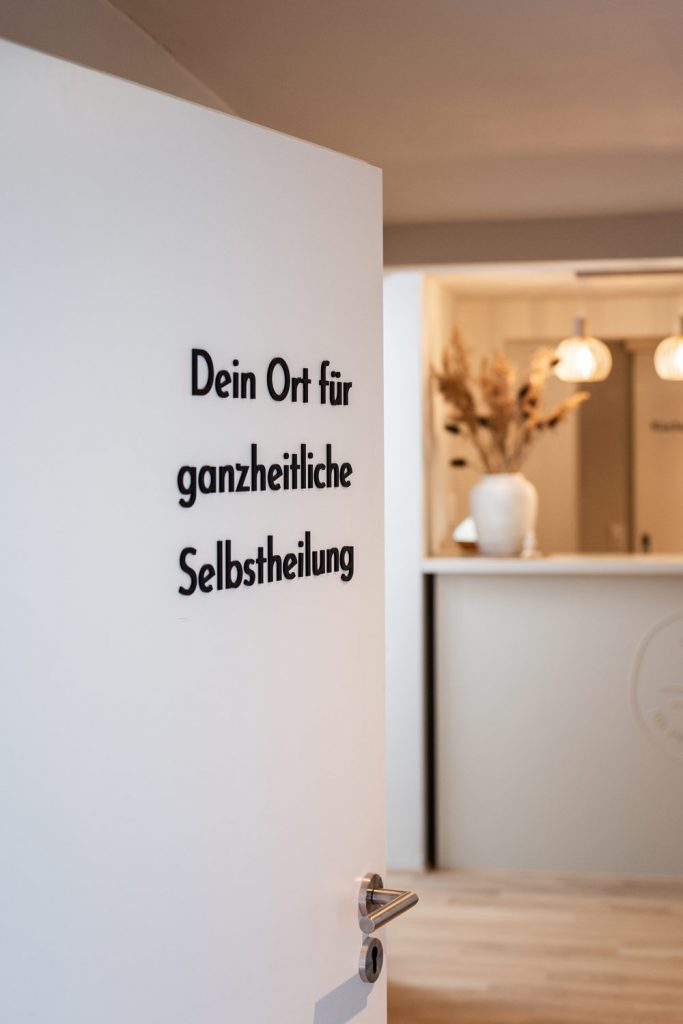Eingangsbereich der Naturheilpraxis mit der Aufschrift: Dein Ort für ganzheitliche Selbstheilung